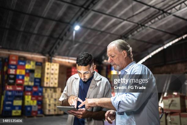 manager che parla con un dipendente in un magazzino - ripostiglio luogo di lavoro foto e immagini stock