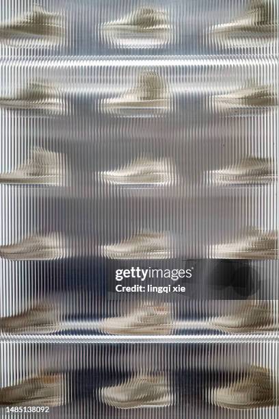 neat shoes on display behind frosted glass - corrugated stock pictures, royalty-free photos & images