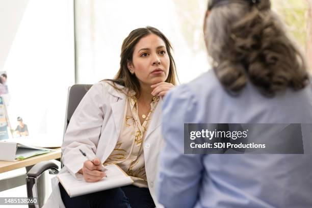 mid adult healthcare professional listens intently to the unrecognizeable patient - listening intently stock pictures, royalty-free photos & images