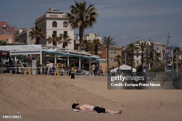 Man sunbathes on the beach of Barceloneta, on 25 April, 2023 in Barcelona, Catalonia, Spain. The State Meteorological Agency forecasts that Spain...