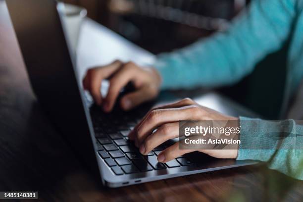 close up of young asian man typing on laptop keyboard at desk. work from home. freelancer working on laptop at cafe. flexible working. people and technology - sending payment stock pictures, royalty-free photos & images