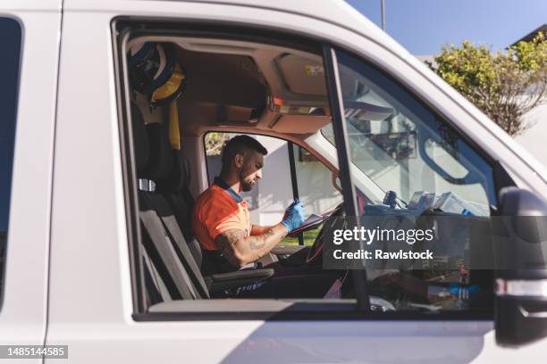 paramedic taking notes of an emergency on a service sheet - ems stock pictures, royalty-free photos & images