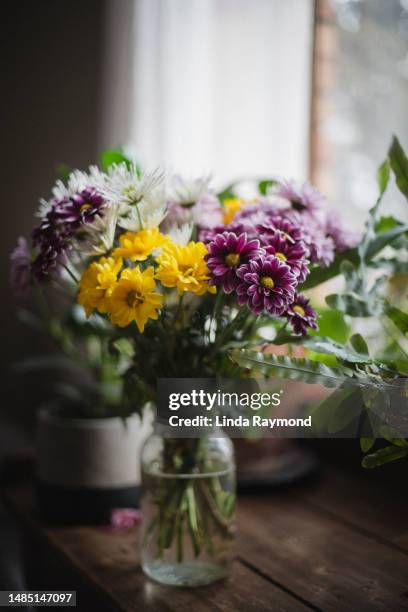 flower bouquet near a window - flower arrangement stock pictures, royalty-free photos & images