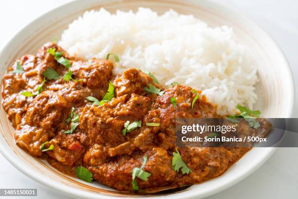 chicken tikka masala with rice on plate - curry stockfoto's en -beelden