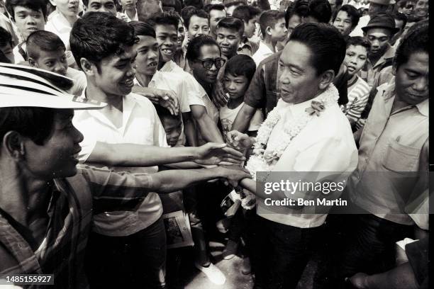 Ferdinand Marcos , the 10th president of the Philippines, greets supporter while campaigning for re-election, Philippines, 1969.