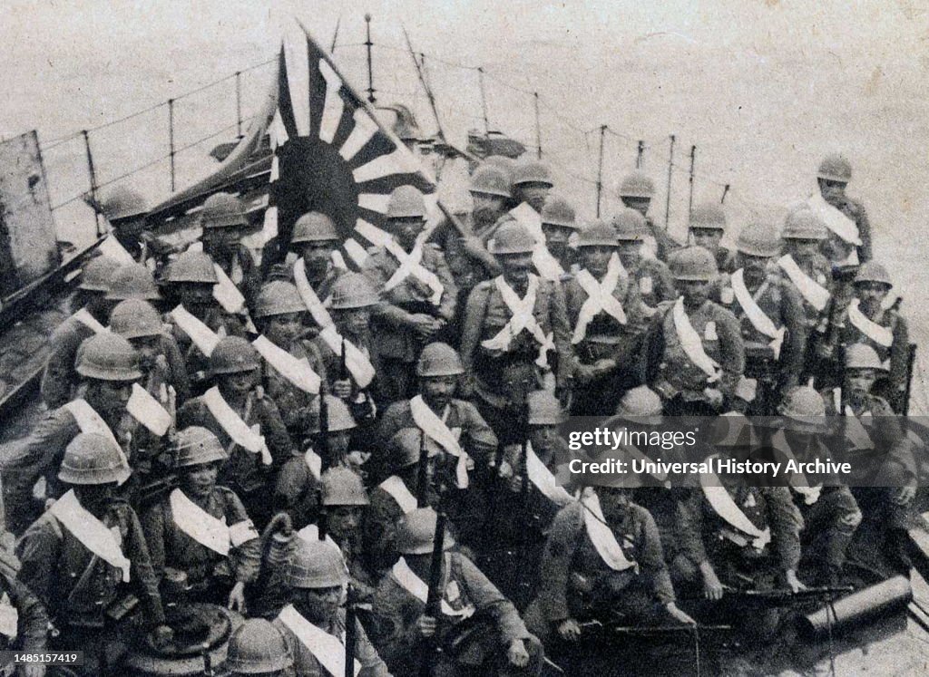 Japanese soldiers with the imperial rising sun flag prepare to land in China as part of the invasion force 1937