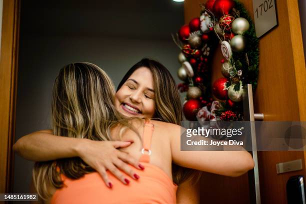 home visit. hug. relatives on christmas night. - reünie sociaal stockfoto's en -beelden