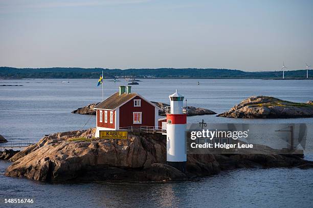 lighthouse and red house on rocky island in gothenburg archipelago, near goteborg. - gothenburg stock pictures, royalty-free photos & images