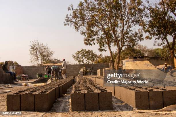 Men are seen working at a brick-making place in Area 49 Habitat, Lilongwe. The cement bricks are now common as they are cosnidered environmentally...