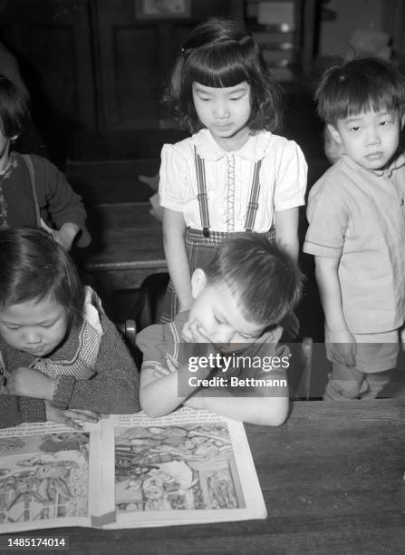 Children attending the kindergarten at the Public School 23 in New York’s Chinatown read together the classic Peter Rabbit by Beatrix Potter.
