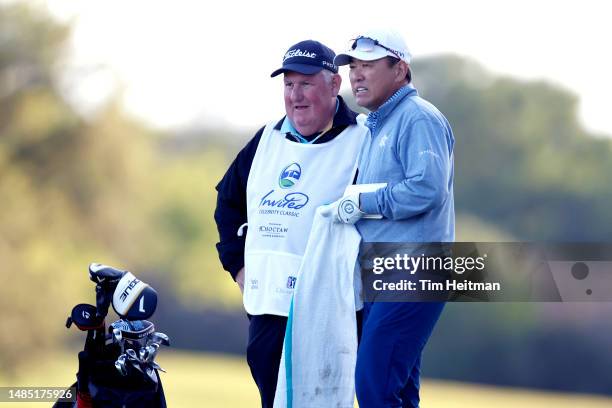 Charlie Wi of South Korea talks with his caddie on the 18th hole during a four hole playoff during the final round of the Invited Celebrity Classic...