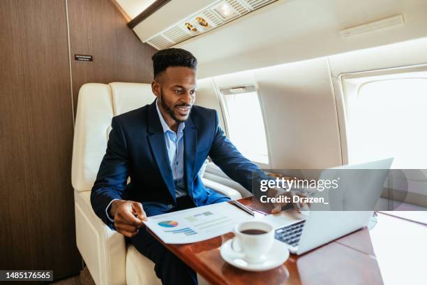 afroamerikanischer geschäftsmann, der mit einem privatflugzeug reist und während des fluges einen laptop benutzt - private aeroplane stock-fotos und bilder