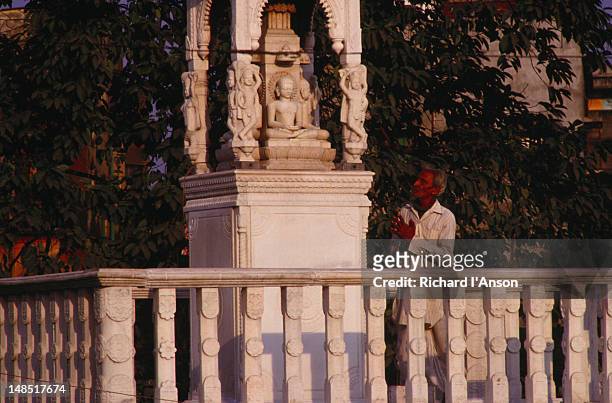 man praying at a shrine in the grounds of the digambara jain temple. - digambara stock-fotos und bilder