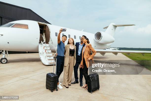 wealthy friends and couples traveling by private jet, taking selfie before the boarding - private wealth stock pictures, royalty-free photos & images