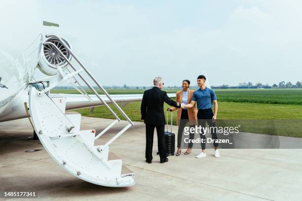 der pilot begrüßt das paar vor dem einsteigen in den luxuriösen mittelgroßen privatjet - private aeroplane stock-fotos und bilder
