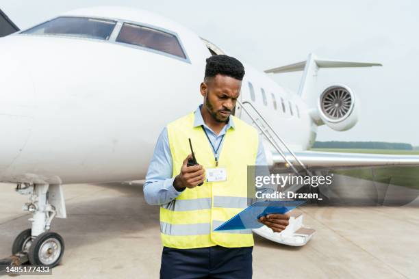 air traffic controller in reflective vest with walkie talkie at the airport - civil aviation stock pictures, royalty-free photos & images