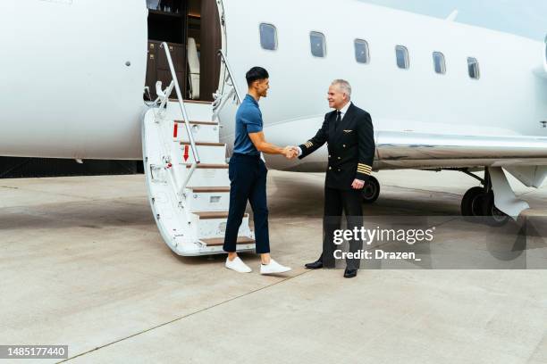 asian passenger using private luxury jet for travel. fin-tech entrepreneur traveling to meeting by private jet - secret handshake stock pictures, royalty-free photos & images