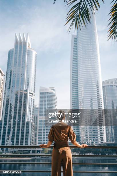 well dressed woman in front of  modern city background - dubai stockfoto's en -beelden