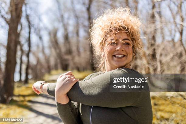 woman with curly hair stretching hands - big fat women stock pictures, royalty-free photos & images