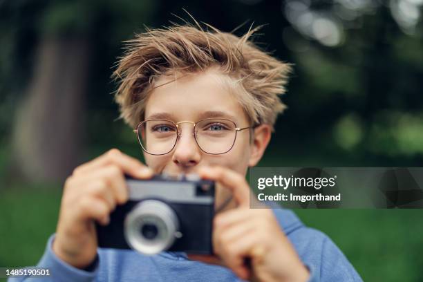 teenager beim fotografieren mit einer vintage-kamera - boy taking picture in forest stock-fotos und bilder