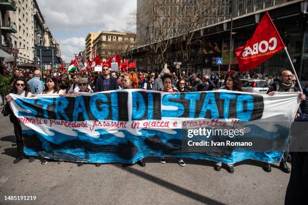 People display a banner that reads Stragi di stato. Minniti e Piantedosi assassini in giacca e cravatta referring to the management of migration...