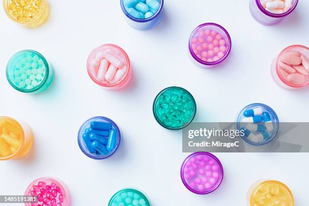 a variety of colorful pills in multi colored pill bottles - generiek geneesmiddel stockfoto's en -beelden