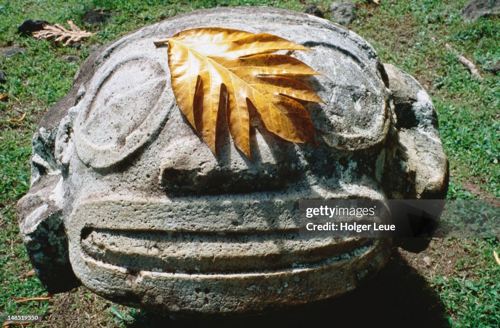 Smiling Tiki and breadfruit leaf, Lipona archeological site.