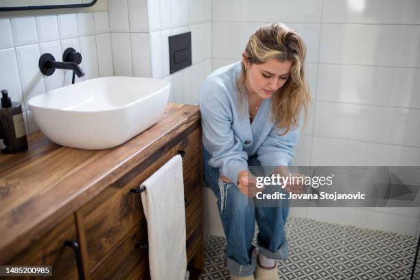 a worried woman is waiting for the results of a pregnancy test - gynaecological examination stock pictures, royalty-free photos & images