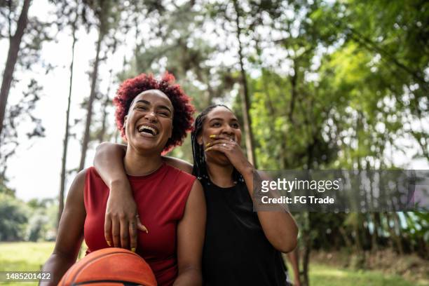 basketball female friends walking on a public park - chatting park stockfoto's en -beelden