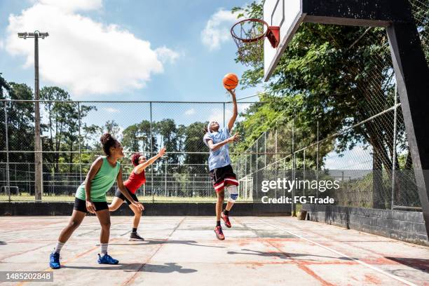 las mujeres jugando al baloncesto - competición de baloncesto fotografías e imágenes de stock