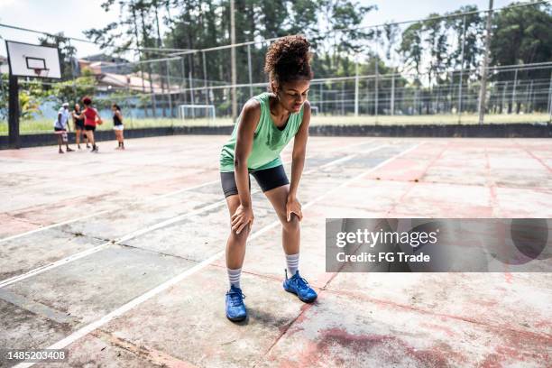 tired young woman in a sports court - hand on knee stock pictures, royalty-free photos & images