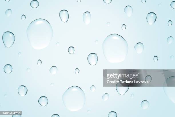 drops of water on glass surface making natural pattern. cosmetics, beauty, self-care, wellness, hydration, moisturizer concept - enzymes cosmetics foto e immagini stock