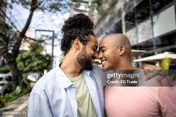 pareja gay abrazada en la calle - hombre gay fotografías e imágenes de stock