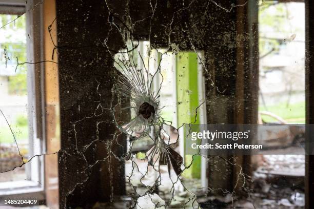 Bullet hole marks a mirror in a destroyed beauty salon, as residents cope with daily life in a Donbas city occupied by Russian forces for six months...