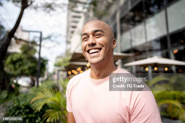 happy young man looking away contemplating outdoors - african american man day dreaming stock pictures, royalty-free photos & images