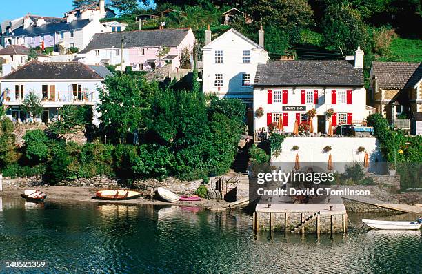 swan inn and other lakeside buildings, noss mayo, near plymouth. - plymouth devon stock-fotos und bilder