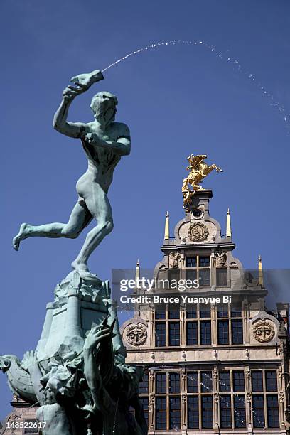 statue of brabo fountain in grote markt (town square) with guilds houses in background. - antwerp stock pictures, royalty-free photos & images