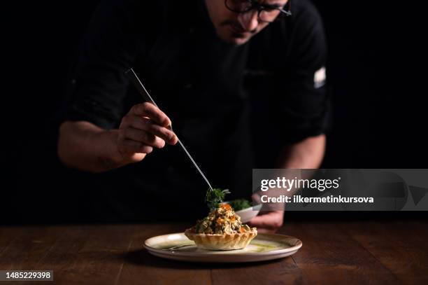 un chef decorando un plato de tartare di pesce spada - preparación de alimentos fotografías e imágenes de stock