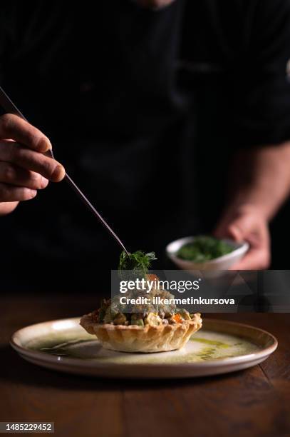 a male chef decorating a plate of tartare di pesce spada - french food stock pictures, royalty-free photos & images