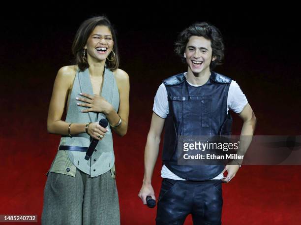 Zendaya and Timothée Chalamet laugh onstage as they promote their upcoming film "Dune: Part Two" during the Warner Bros. Pictures Studio presentation...