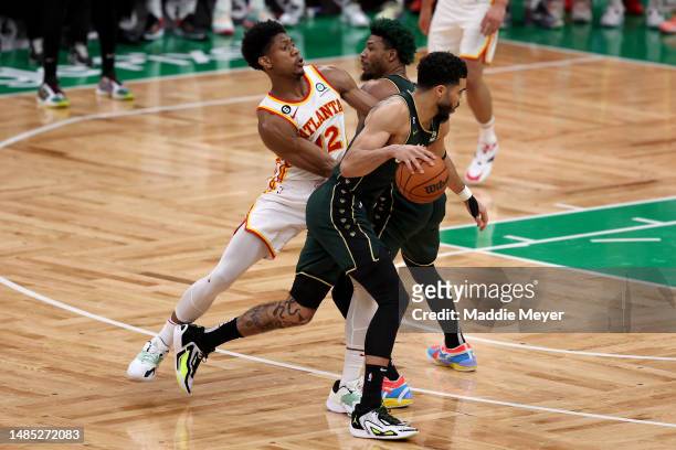 Marcus Smart of the Boston Celtics sets the pick against De'Andre Hunter of the Atlanta Hawks for Jayson Tatum during the fourth quarter in game five...