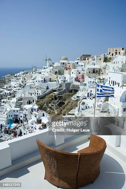 round lounge chair and cliffside houses. - greek independence day stockfoto's en -beelden