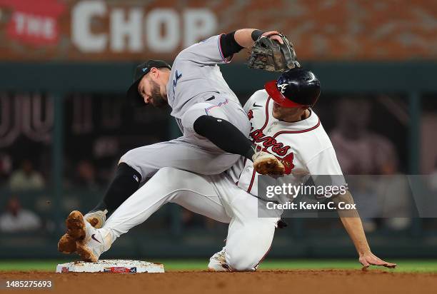 Jon Berti of the Miami Marlins collides with Matt Olson of the Atlanta Braves as he turns a double play in the seventh inning at Truist Park on April...