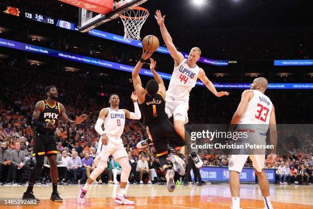 Devin Booker of the Phoenix Suns shoots the ball as he is defended by Mason Plumlee of the LA Clippers during the fourth quarter in game five of the...