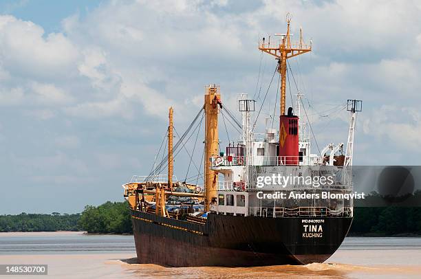 cargo ship heading upriver to collect cargo of cut wood on lower batang rejang near sibu. - sibu river stock pictures, royalty-free photos & images