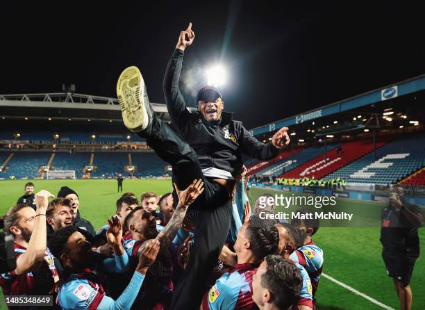 Vincent Kompany, Manager of Burnley, is lifted up by his players after winning the Sky Bet Championship following victory against Blackburn Rovers...