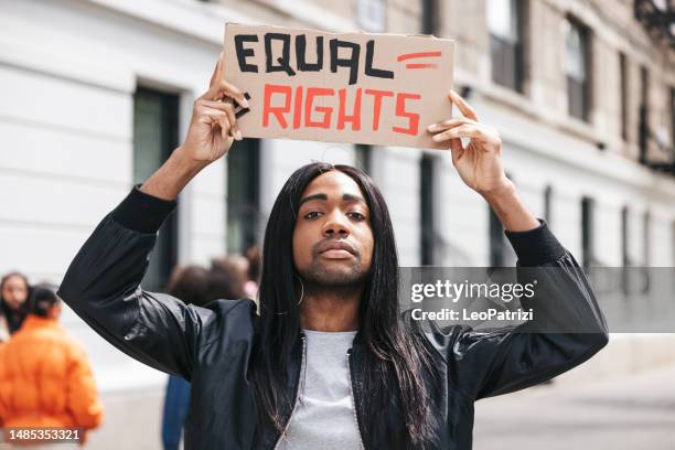 non-binary person portrait with a equal rights sign on cardboard - march stock pictures, royalty-free photos & images