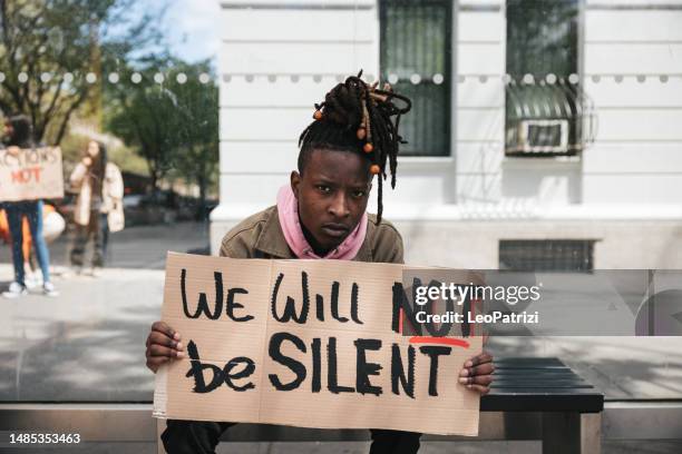 young man portrait with a equal rights sign on cardboard - civil rights stock pictures, royalty-free photos & images