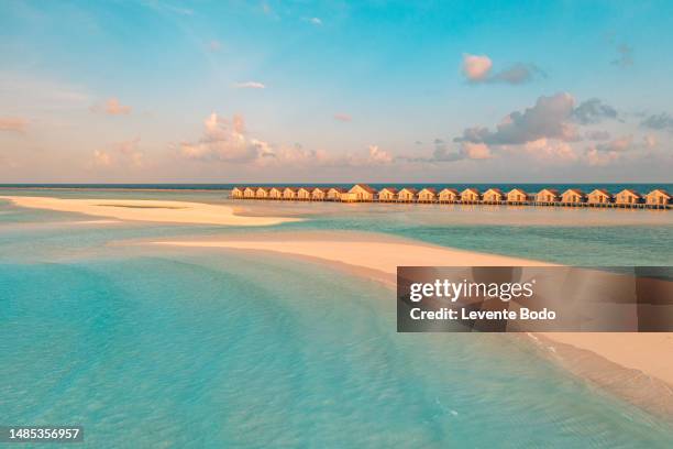 aerial view of overwater bungalows villas in the maldives. sunset sea bay lagoon, sandy beach shore. luxury destination scenic, summer vacation concept - bungalow stock pictures, royalty-free photos & images