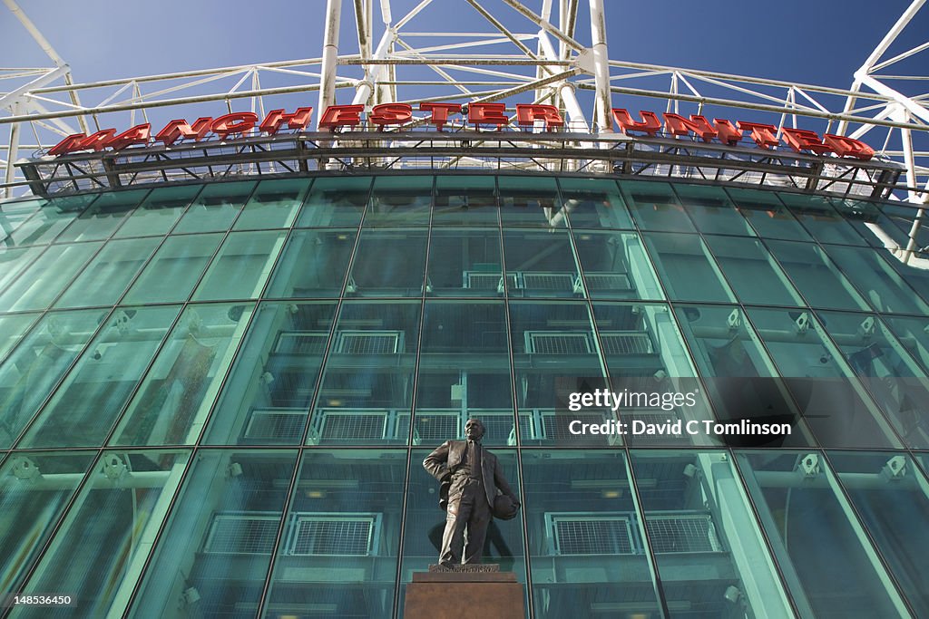East facade of the Manchester United football stadium, statue of former manager Sir Matt Busby prominent, Old Trafford.